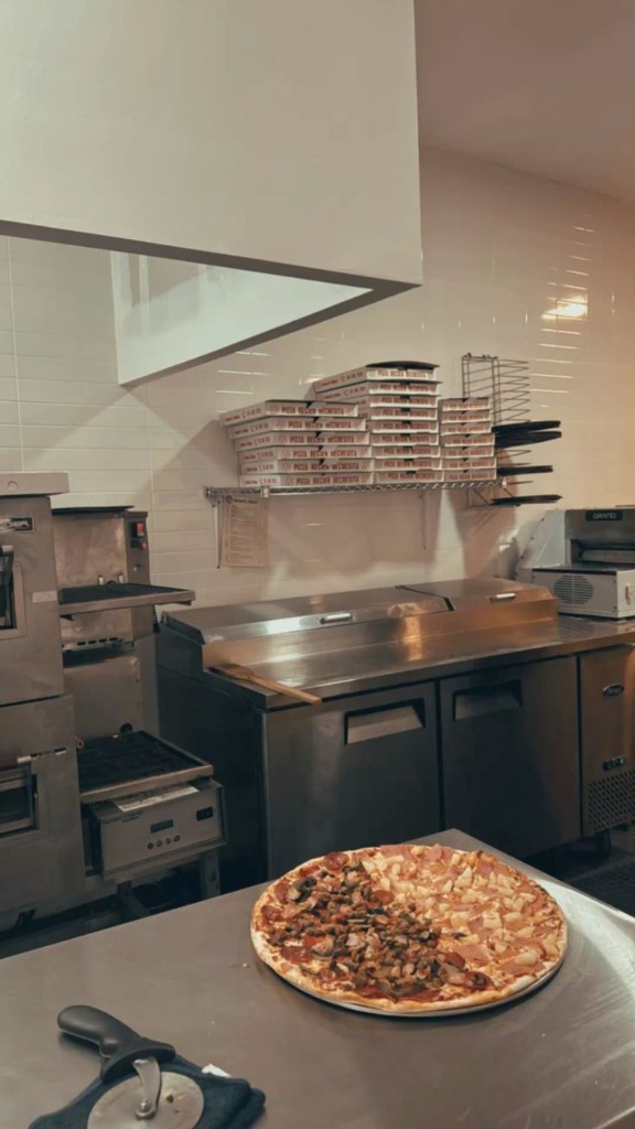 Kitchen counter with fresh pizza and boxes